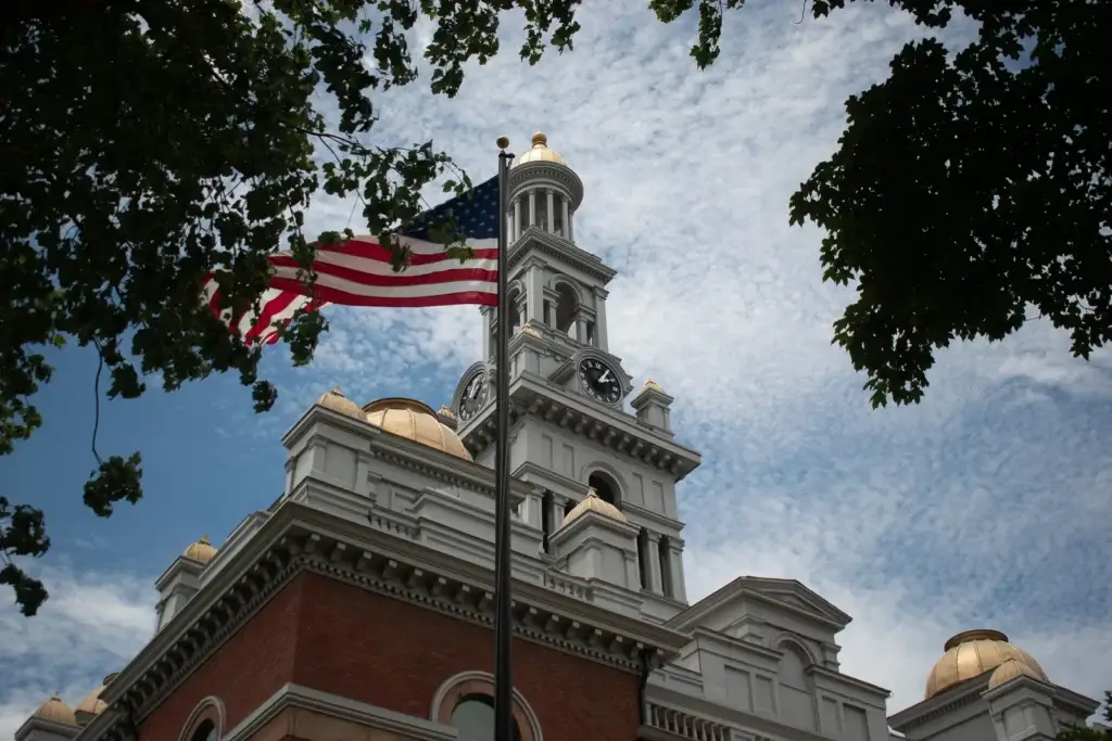 United States flag flying beside a historic courthouse