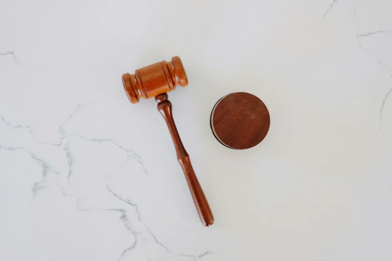 Wooden judge's gavel and sound block on white marble