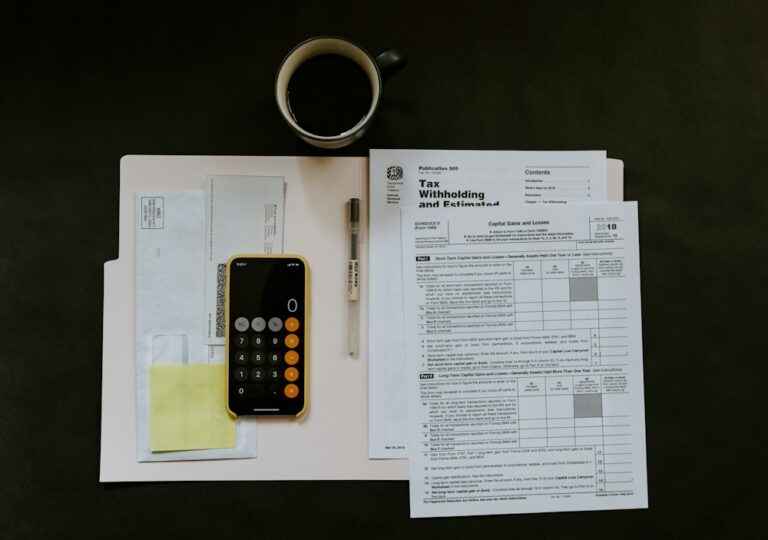 Tax forms, calculator and coffee on a desk